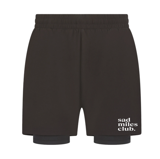 Black shorts with 'sad miles club' text on a white background