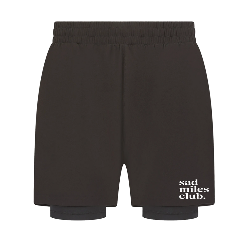 Black shorts with 'sad miles club' text on a white background